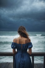 A depressed lonely woman is standing on an ocean shore wearing a blue dress, AI generated