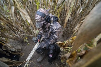 Hunter loads his self-loading shotgun in the umbrella