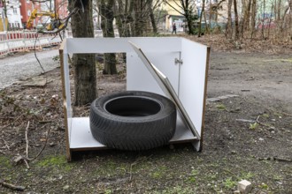 A car tyre lies in a broken kitchen cupboard, illegal waste disposal in the Berlin district of