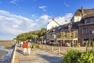 People walking on the boardwalk in Morgat village with restaurants in the evening light, Morgat,