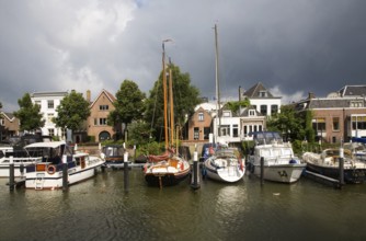 Sailing boats in Maartensgat harbour with dramatic lighting after recent rain storm, Dordrecht,