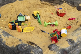 Sandpit, on a children's playground, sandpit with various plastic toys, excavator, shovels, moulds