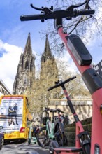 Electric scooters, e-scooters are parked in large numbers on the Burgmauer road, in front of