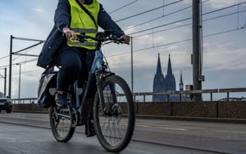 Cycling in the city, cyclist on the Deutzer Bridge in Cologne, Cologne Cathedral, cycle path, North