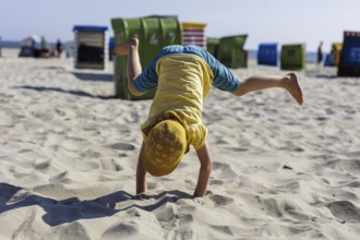 Toddler doing a handstand on the North Sea island of Borkum, 18/05/2024