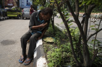 Homeless people eats food being distributed by volunteers along the roadside, on October 11, 2024