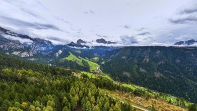 The peaks of the rose garden, shrouded in mist, drone shot, Dolomites, Autonomous Province of