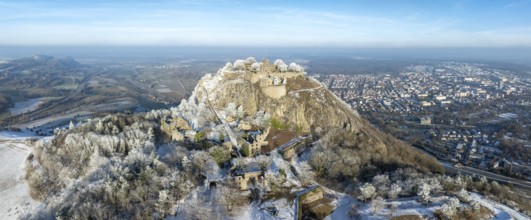 Aerial panorama of the snow-covered Hegau volcano Hohentwiel with Germany's largest castle ruins,