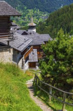 Hiking trail through the historic village centre, behind the Saint Theodule church, Grimentz, Val