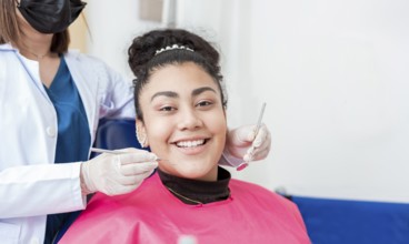 Dentist doctor examining mouth to female patient looking at camera. Dentist with probe and dental