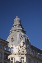 Old architectural building decorated with ornate details including a sculpture of a Mother and her