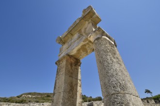 Stone ancient column rises under a clear blue sky, Kamiros, Archaeological site, Ancient city,