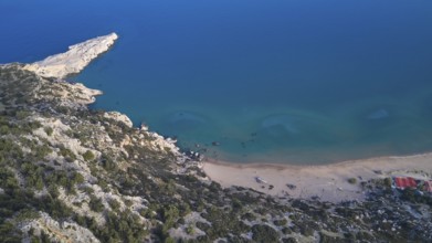 Aerial view of a secluded beach with clear blue water and rocky coastline, Tsambika Beach,