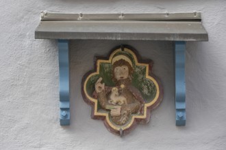 Fresco of St Agnes with a lamb, above a protective roof on a town house, Villingen-Schwenningen,