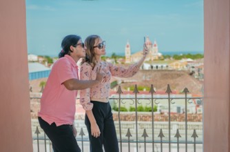 Tourist couple taking a selfie at the viewpoint of the La Merced church. Happy tourists taking self