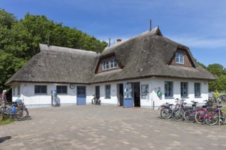 White thatched house with bicycles at your feet on a sunny day, Rügen, Hiddensee