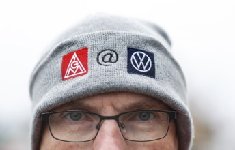 A Vokswagen employee wears a cap with IG Metall and Volkswagen logo during the collective