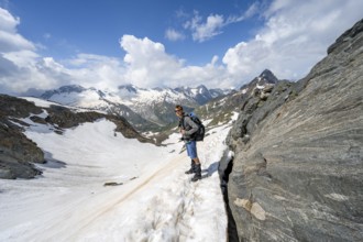 Mountaineer on a hiking trail with snow, ascent to the Nordliche Mörchnerscharte, behind mountain