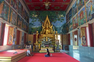 Man and woman sitting in dialogue in a prayer hall in the Buddhist temple Wat Plai Laem, Koh Samui,