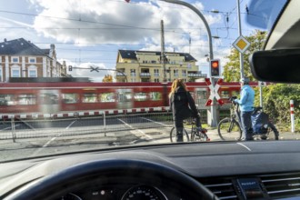 Barred level crossing, closed barrier, St Andrew's cross, traffic lights, S-Bahn train passing,