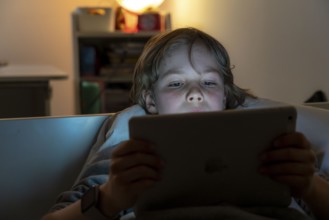 A boy plays computer games on a tablet PC