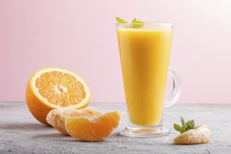 Glass of orange juice on a gray and pink background. Morninig, spring, healthy drink concept. Side