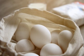 Symbolic image of baking ingredients: Eggs in a cloth bag