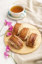 Traditional armenian dessert gata with cup of green tea on a gray concrete background and linen