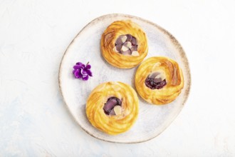 Small cheesecakes with jam and almonds with cup of coffee on a white concrete background. top view,