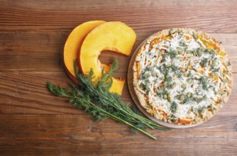 Sweet pumpkin pie with cheese and dill on brown wooden background. top view. copy space