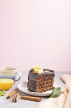 Homemade chocolate cake with orange and cinnamon with cup of coffee on a gray and pink background