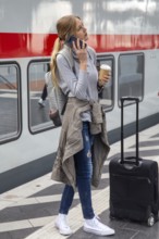 Young woman standing on the railway track in front of a train