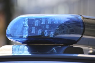 Symbolic image of a police operation: close-up of a flashing blue light on a police car