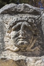 Close-up of sculpted male face on stone wall in the old Croatian public Square, Old Town of Zadar,