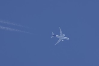 Airbus A300 jet aircraft of Fedex airlines flying in a blue sky with a vapor trail or contrail