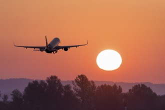 Passenger aeroplane after take-off, sunrise, sun, trees, Baden-Württemberg, Germany, Europe