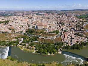 City view of a historic city with river and surrounding hills under a cloudy sky, aerial view,