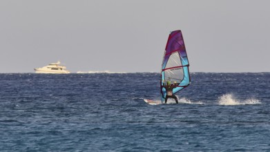 Windsurfer near a yacht in the middle of the blue sea, windsurfer, Meltemi windsurfing spot, Devils