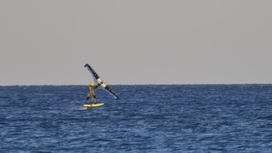 Wingfoiller, single kitesurfer over the waves of the calm sea, windsurfer, Meltemi windsurfing