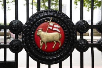 Badge or coat of arms, holy lamb and flag on black wrought iron Tor tor, entrance The Inns of