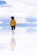 Young woman walks across the Uyuni salt lake, Salar de Uyuni, Uyuni, Bolivia, South America