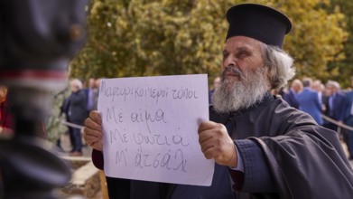 Priest holding a sign in the midst of a crowd in autumnal surroundings, Visit of the Federal