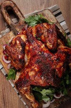 Whole fried chicken, with spices, grilled chicken, on a chopping board, top view, homemade, no