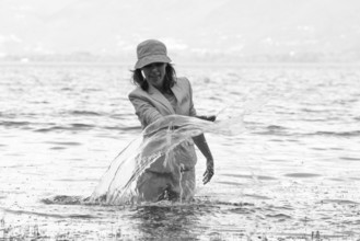 Woman Standing in a Flooding Alpine Lake with Snow-capped Mountain in Locarno, Switzerland, Europe