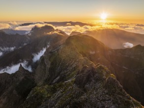 Aerial drone view of mountains over clouds near Pico Ruivo on sunset. Madeira island, Portugal,