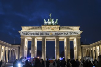 A banner For Democracy in Syria / Defend Rojava hangs at the Brandenburg Tor, Berlin, 16 December