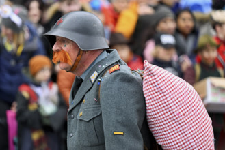 Person masked as a soldier HD-Läppli at the carnival parade of the Wey guild on Rose Monday,