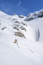 Lone ski tourer in mountain landscape with snow, ascent to Wildstrubelhütte, Bernese Alps,