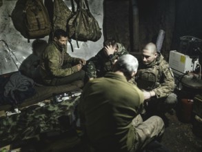 Iura, Volodymyr, Daniel and Ruslan wait with a 122 mm artillery gun from Soviet stocks for the