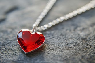 Close up of elegant red heart shaped gem stone pendant with silver necklace. Generative Ai, AI